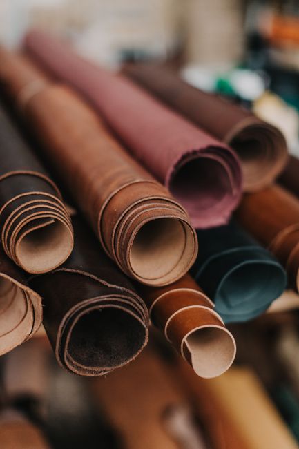 Close-up of various colored leather rolls in a workshop, featuring texture and vibrant hues.